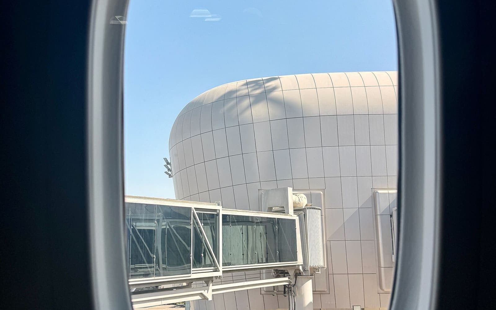 An airplane window on an international flight